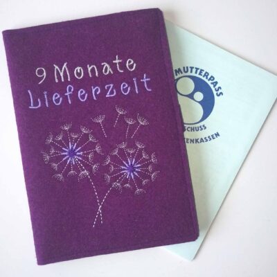 Lila Wollfilzhülle für den Mutterpass mit Pusteblume